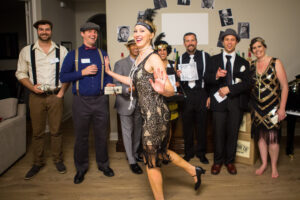 Night of Mystery | How to Throw the Ultimate Masquerade Mystery Party: A Step-by-Step Guide to an Unforgettable Night Party guests engaging in interactive mystery game in roaring twenties costumes