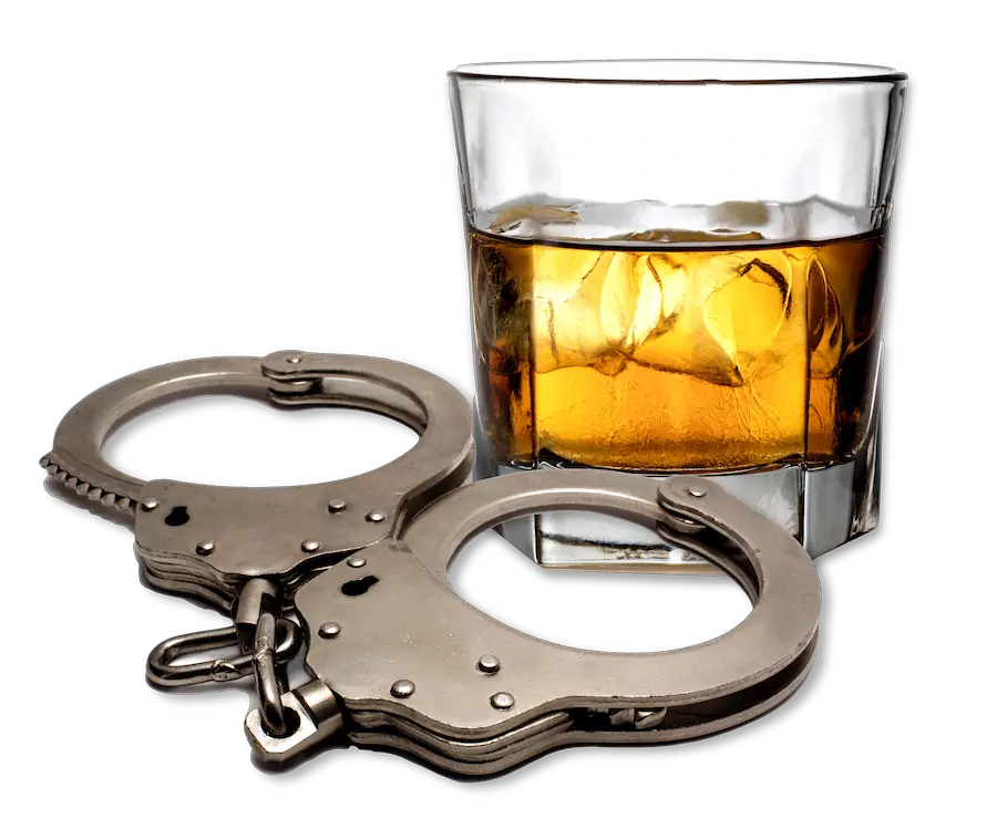 Glass of whiskey with ice alongside a pair of metal handcuffs, set against a black background.
