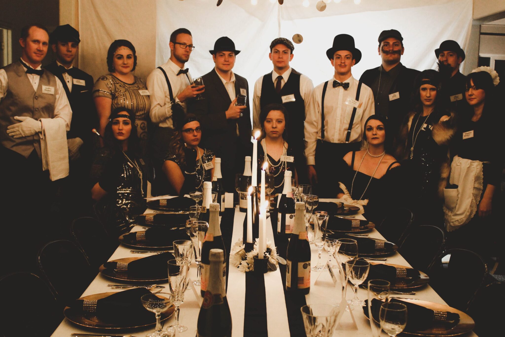 Guests in 1920s costume interrogating each other at a Murder of a Millionaire party