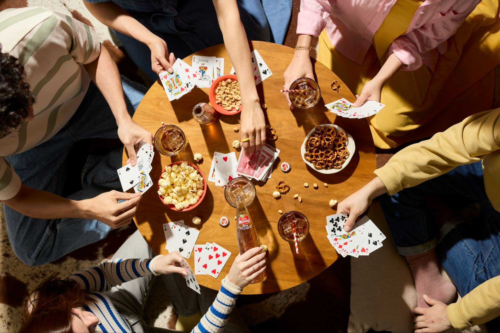 Friends Playing Cards and Eating Snacks During Game Night