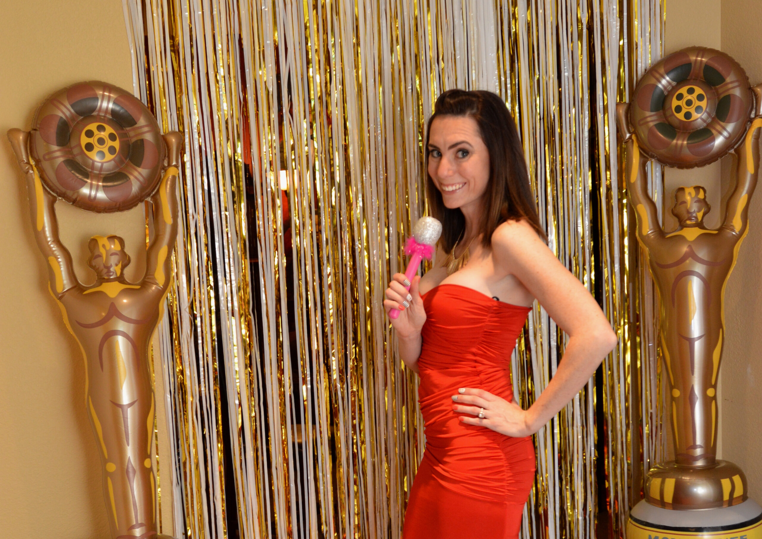 Guests dressed in elegant gowns and tuxedos posing at a red carpet event.