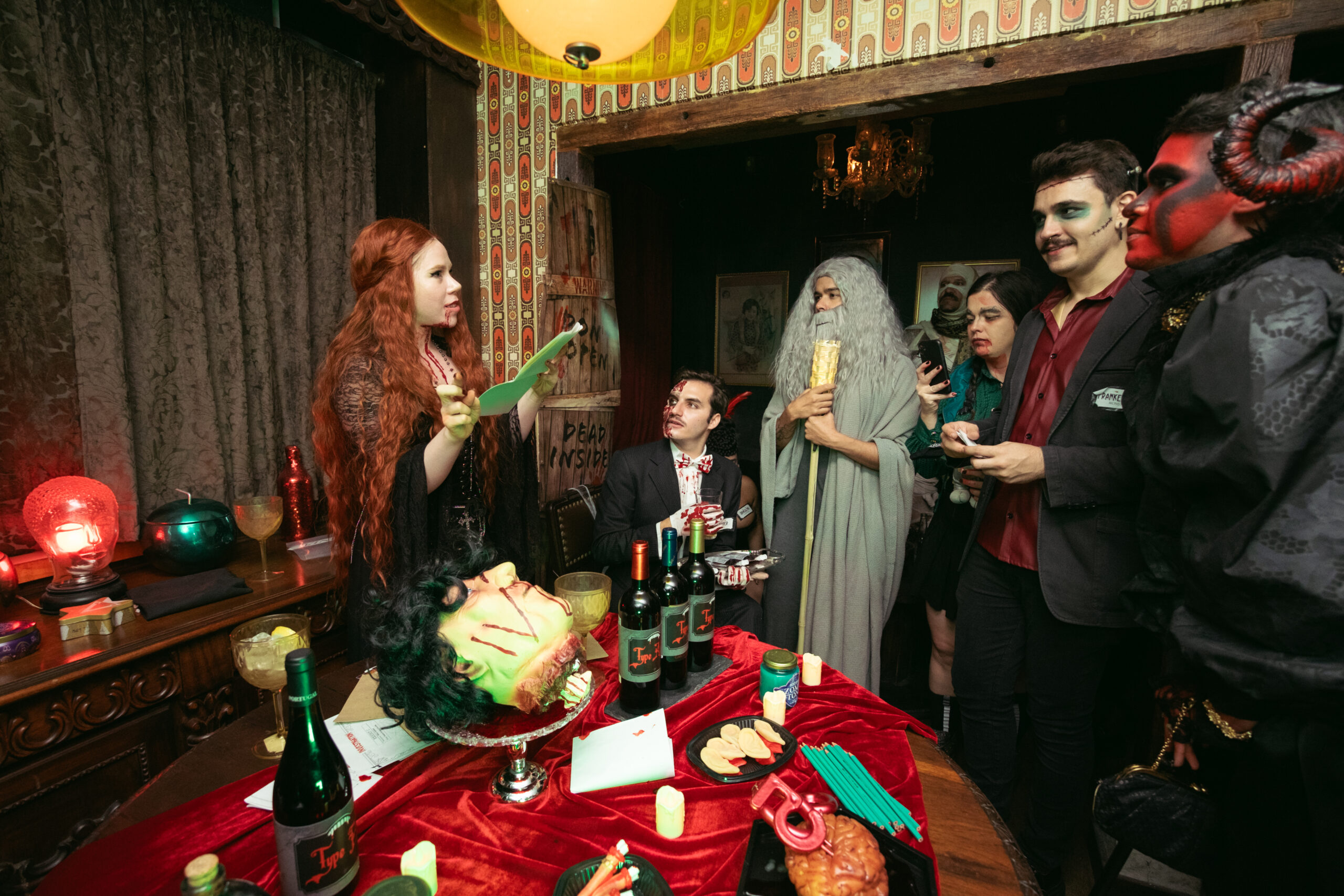 Guests dressed as villains at a murder mystery party with dim lighting, dark decor, and crime scene elements