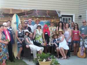Friends in costume enjoying a summer murder mystery party in a backyard setting