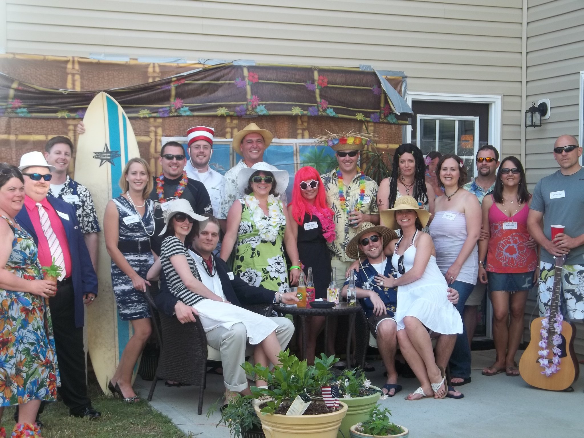 Friends in costume enjoying a summer murder mystery party in a backyard setting