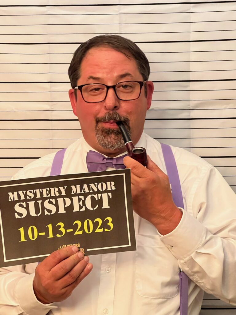 Mugshot backdrop and suspect sign for a murder mystery party photo booth