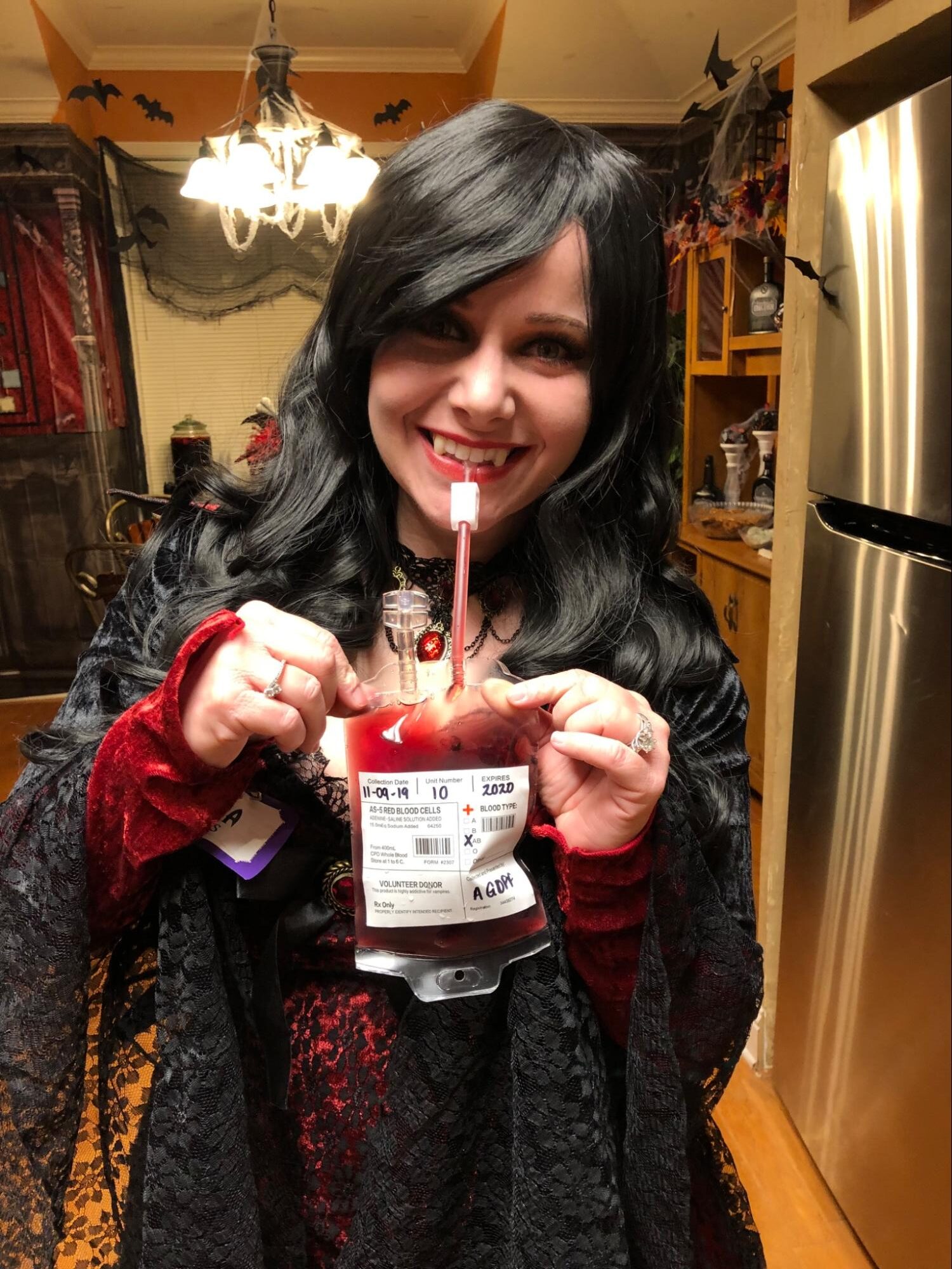Halloween guests holding blood bag cocktails.