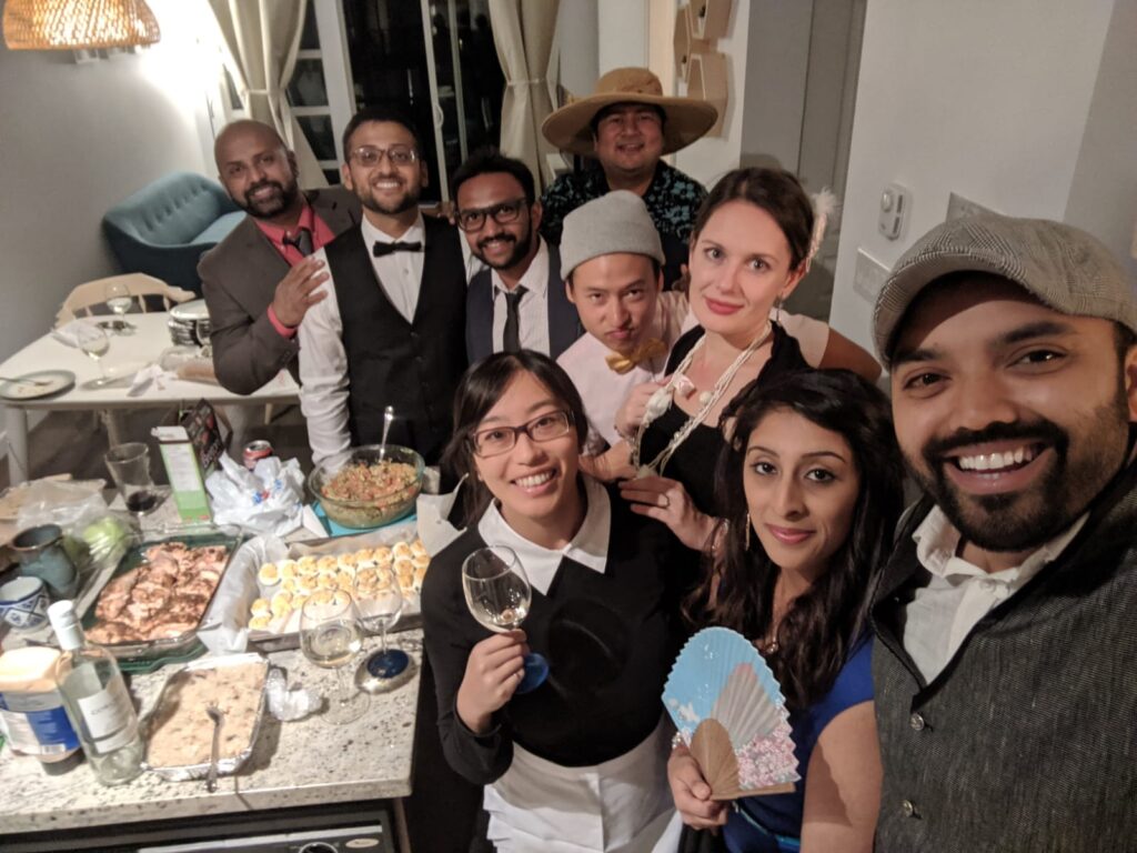 Friends laughing while playing fun Friendsgiving games like charades.