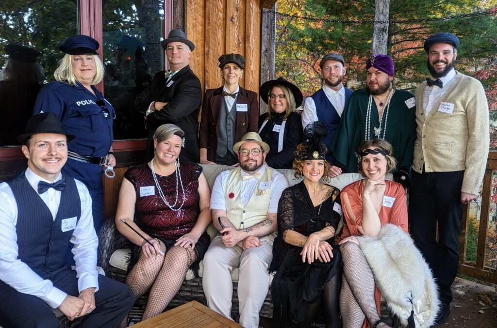 Group of friends celebrating with wine at the end of a Friendsgiving murder mystery party.