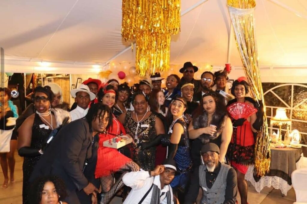 Adults dressed up and laughing while playing a New Year’s Eve mystery party game