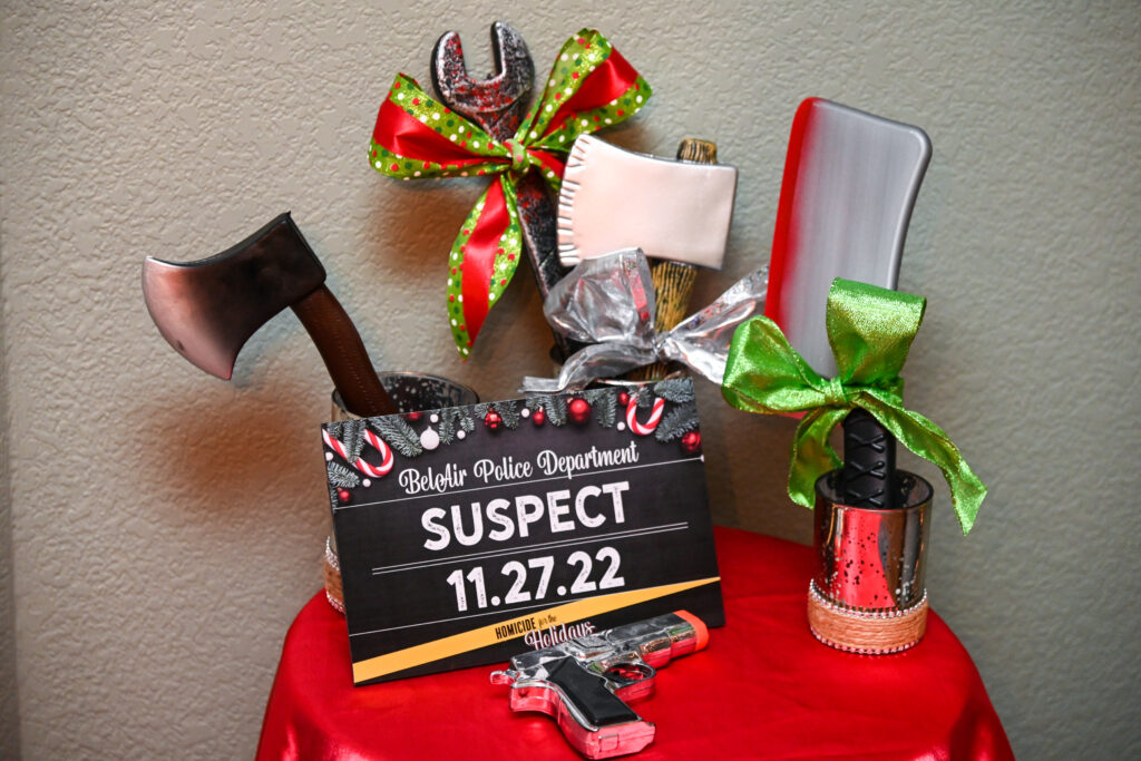 Printed mystery game materials surrounded by Christmas decorations and cocoa.