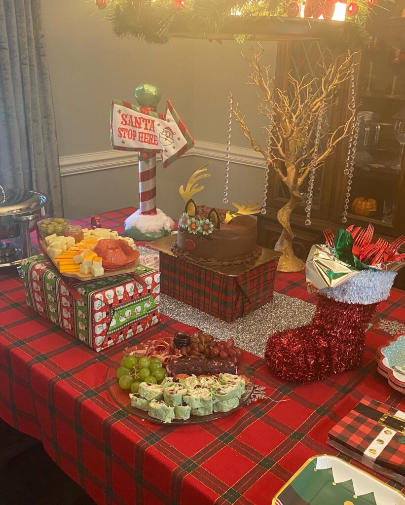 Festive snack table with themed treats for a Christmas mystery party.