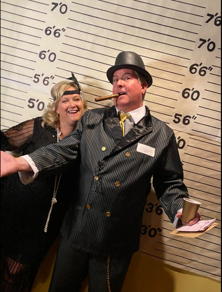 Guests in elaborate masquerade costumes posing at a Night of Mystery event.