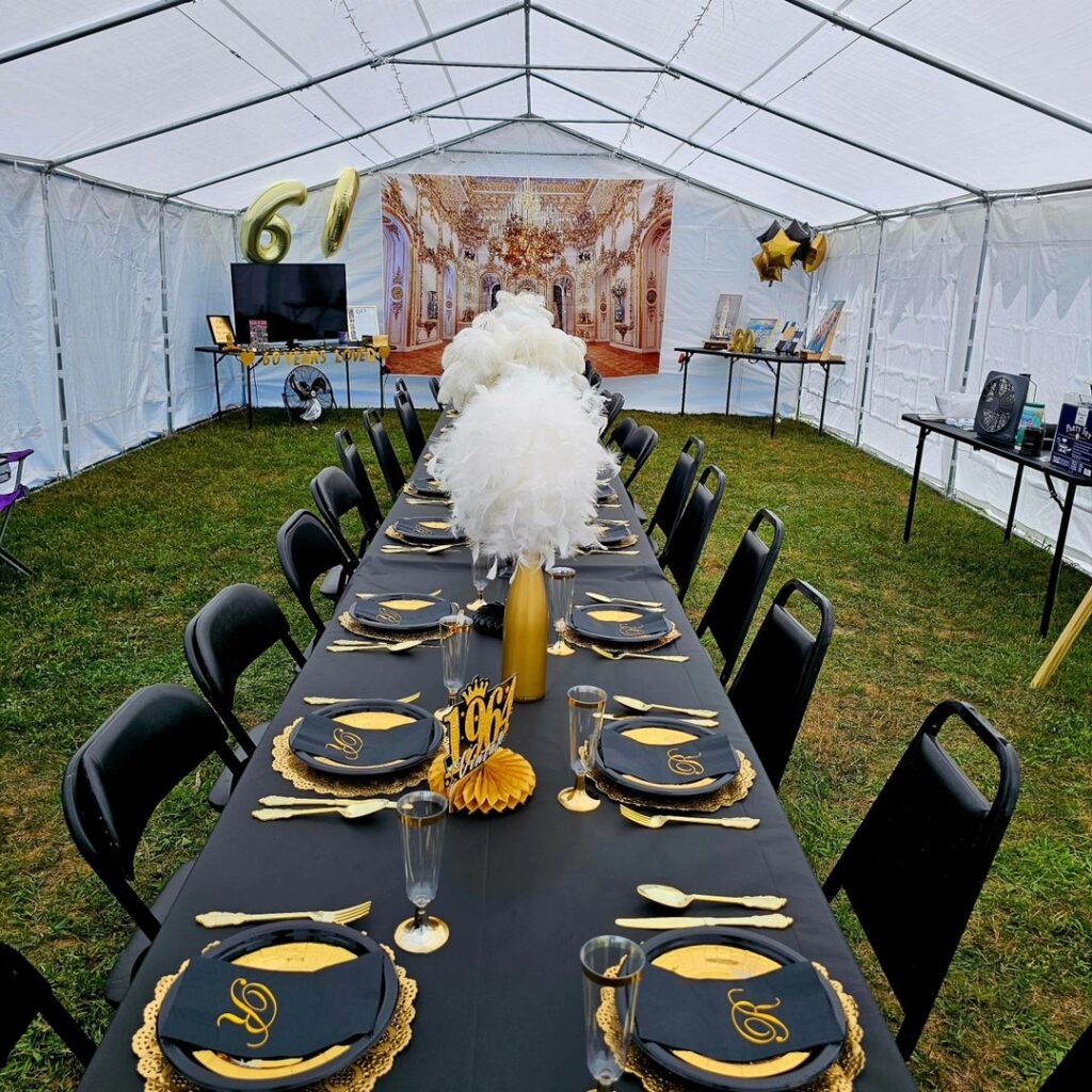 Candlelit masquerade party table with feathers, gold, and mask centerpieces.