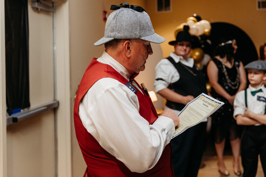 Players dressed in masquerade costumes solving clues at a Night of Mystery game.