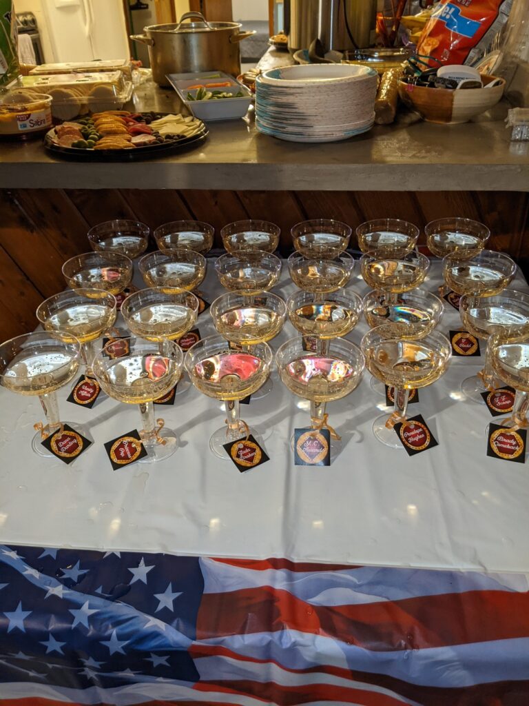 Hands arranging coupe glasses into a square base for a champagne tower