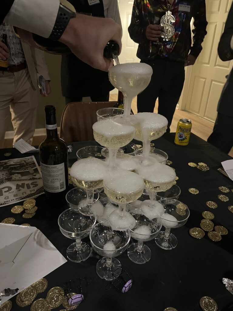 Pouring champagne into the top glass of a champagne tower with champagne cascading down