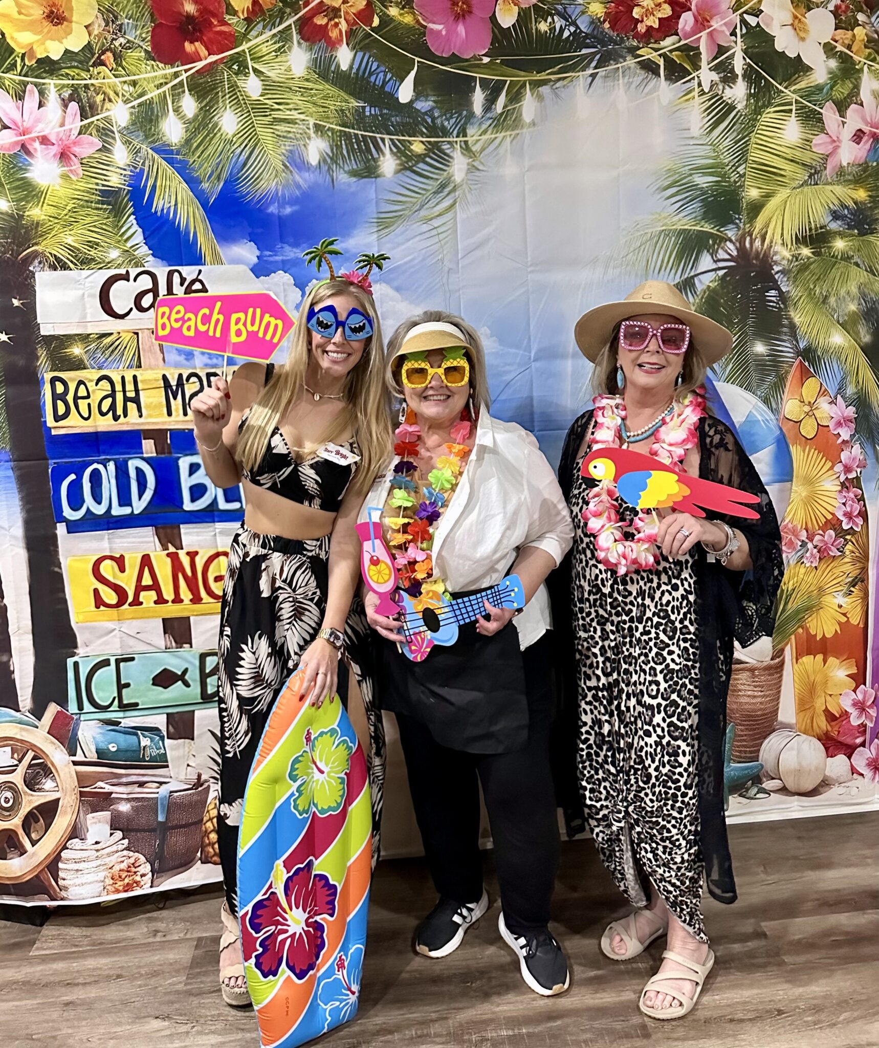 women posing for a group picture with a summer-themed backdrop