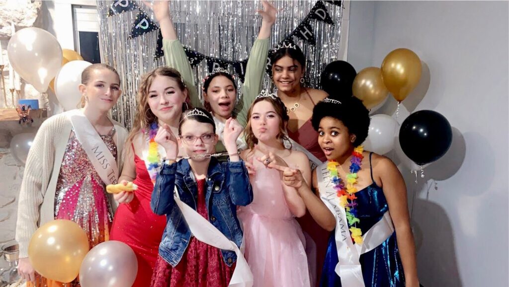 Night of Mystery | Sleepover Games For Teens And Tweens That Beat Truth Or Dare A group of young girls posing playfully together at a pageant-themed birthday party.